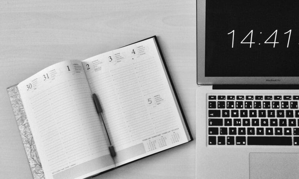 flat lay photography of unfold book beside macbook