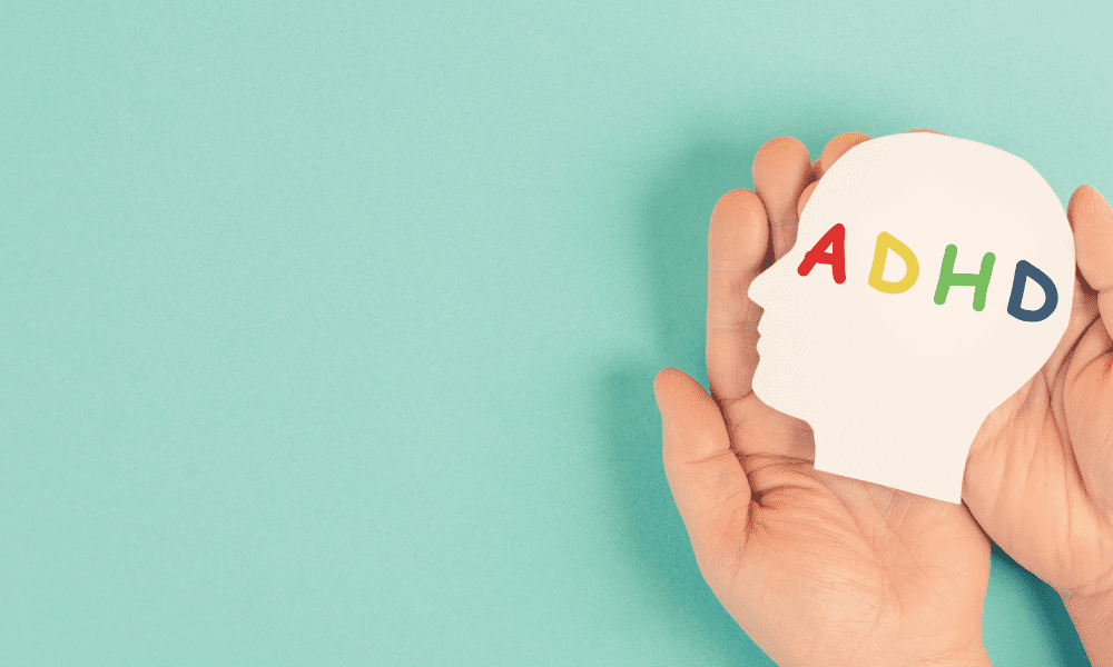 Hand holding a sign that reads ADHD