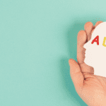Hand holding a sign that reads ADHD
