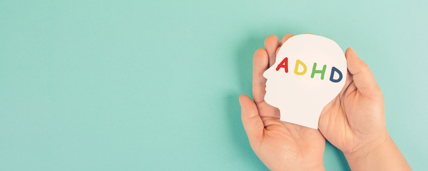 Hand holding a sign that reads ADHD